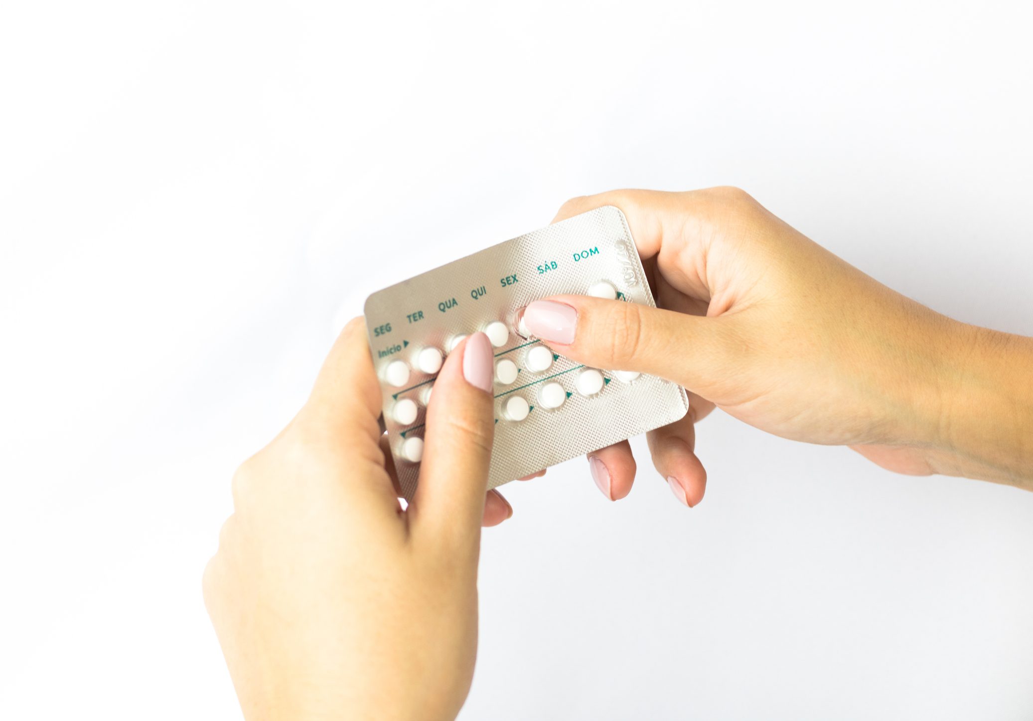 Hands holding a blister pack of pills.