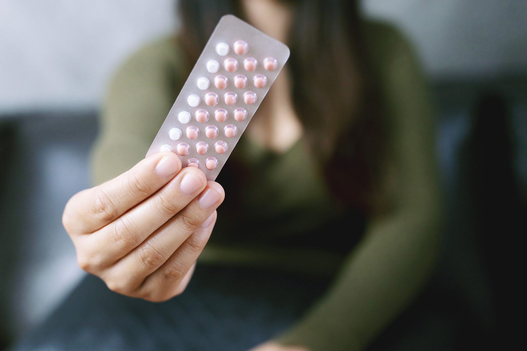 Person holding a pack of contraceptive pills.