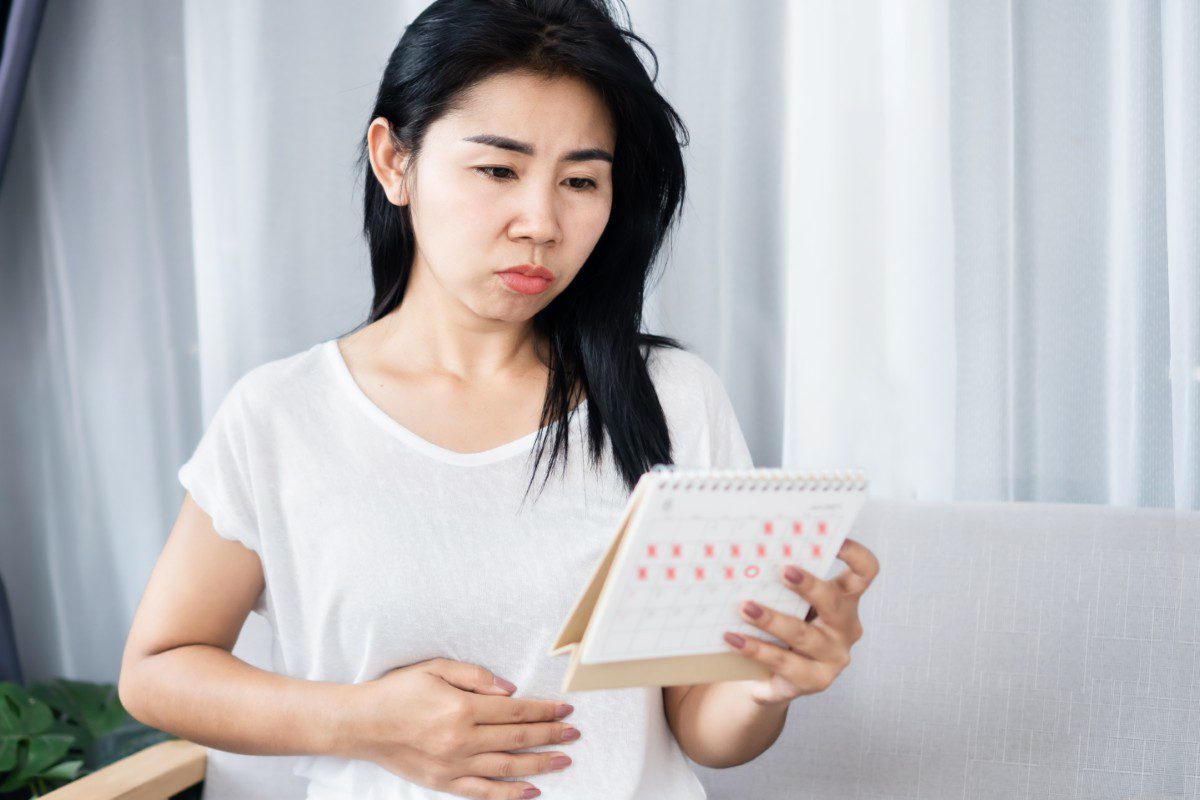 Woman holding calendar, looking concerned.