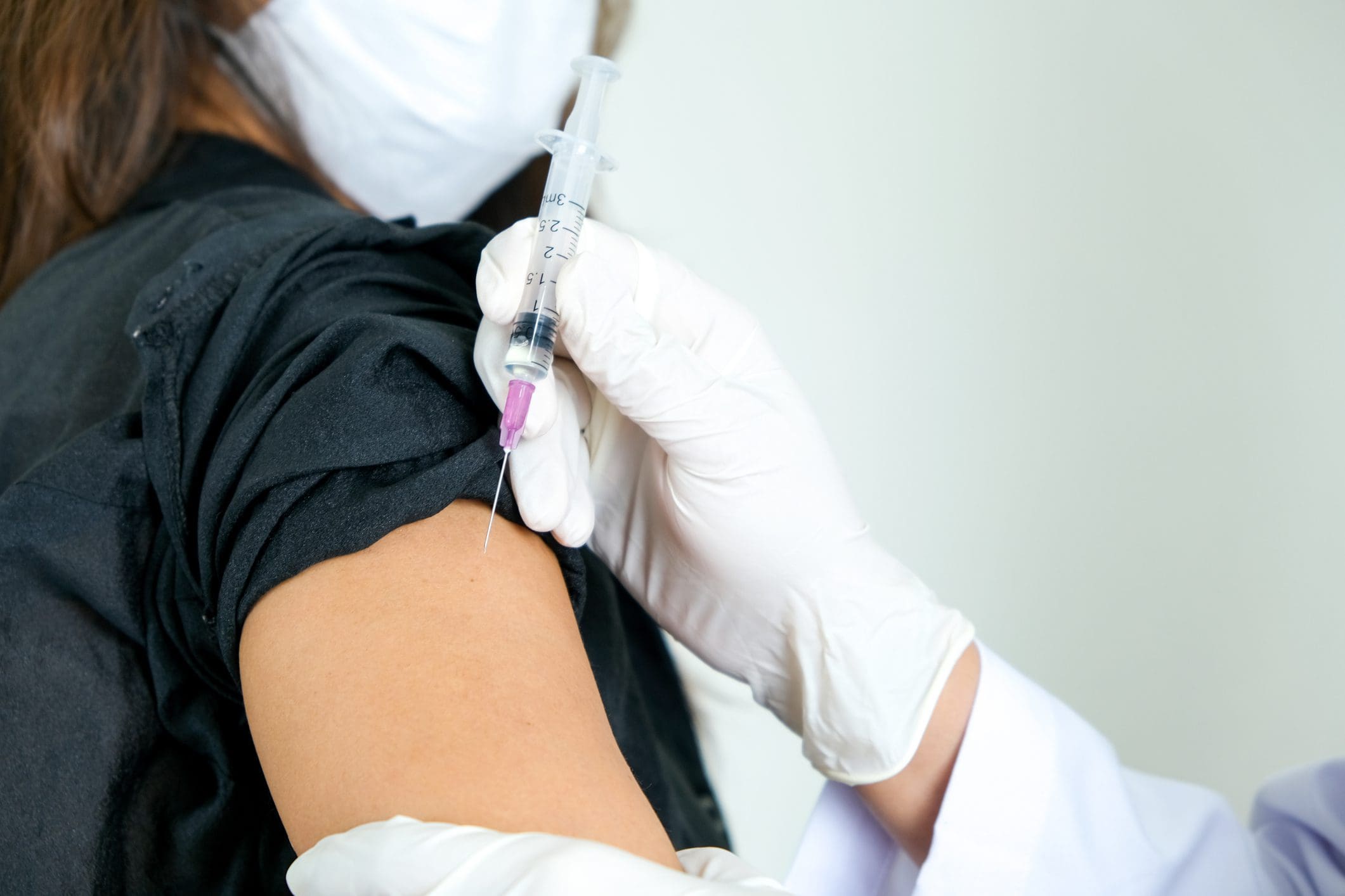 Person receiving vaccine in upper arm.