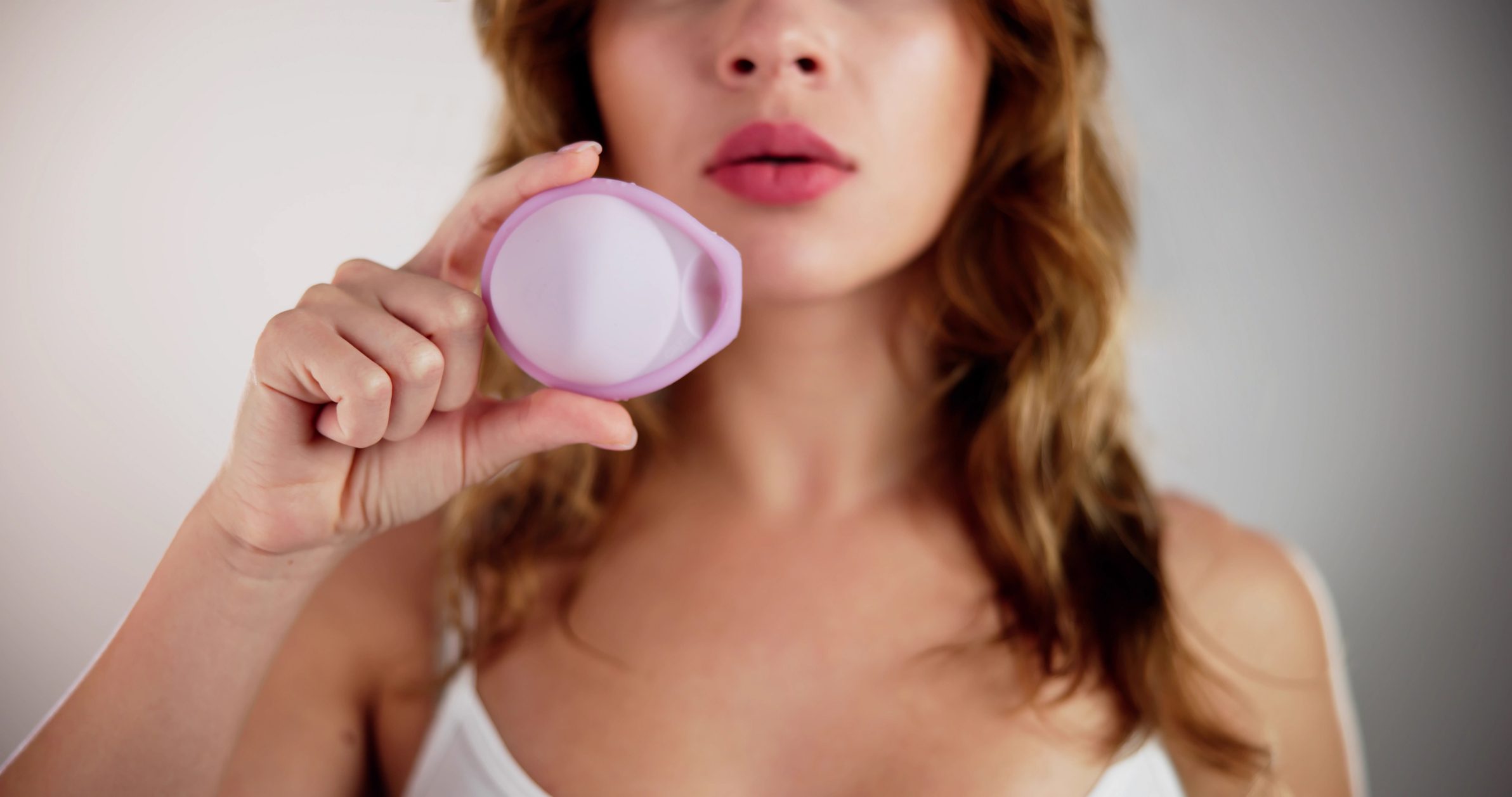 Woman holding a pink round object.