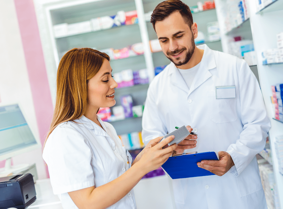 Pharmacists discussing medication in a pharmacy.