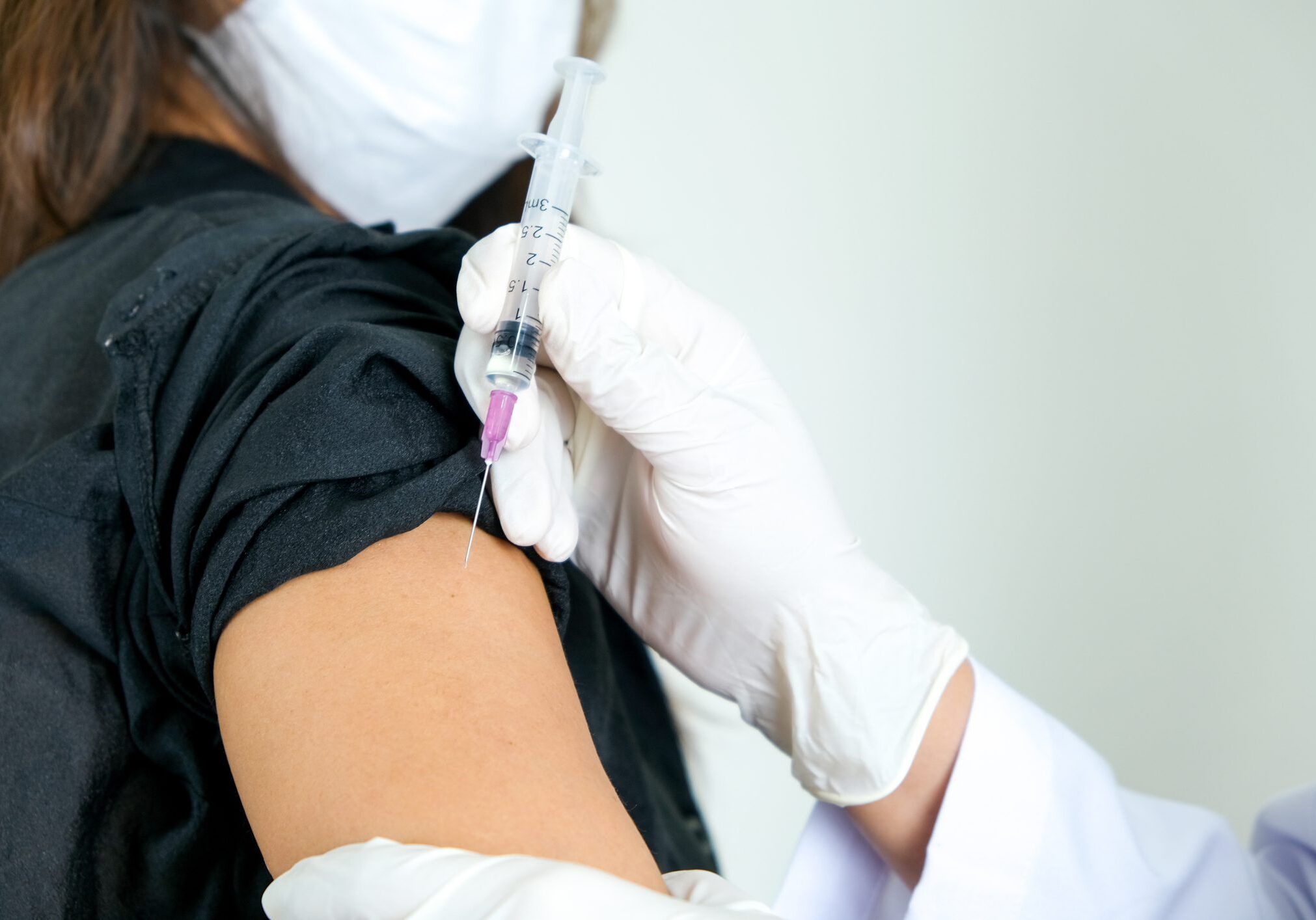 Person receiving vaccine in upper arm.
