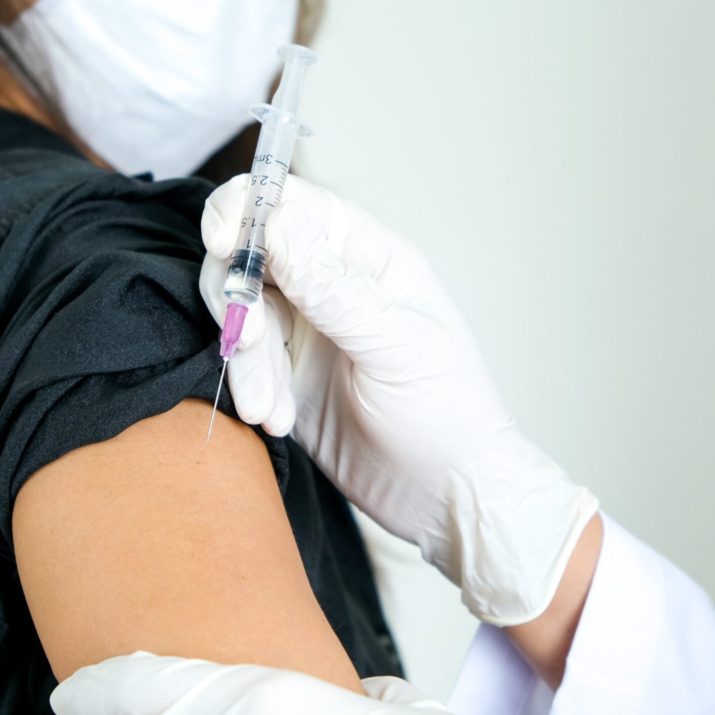 Person receiving vaccine in upper arm.